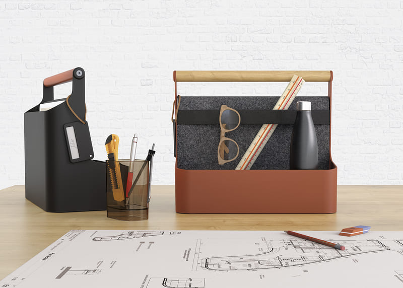 Deux versions de la boîte YouMe sur un bureau, remplies de fournitures et d’outils professionnels, avec un design moderne et minimaliste.