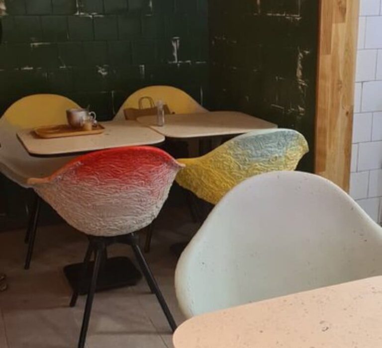 Chaises aux textures uniques et aux couleurs éclatantes, fabriquées en matériaux recyclés, apportant une touche artistique à un espace cosy.